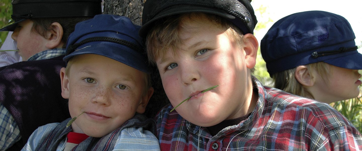 Två pojkar i gammaldags kläder.