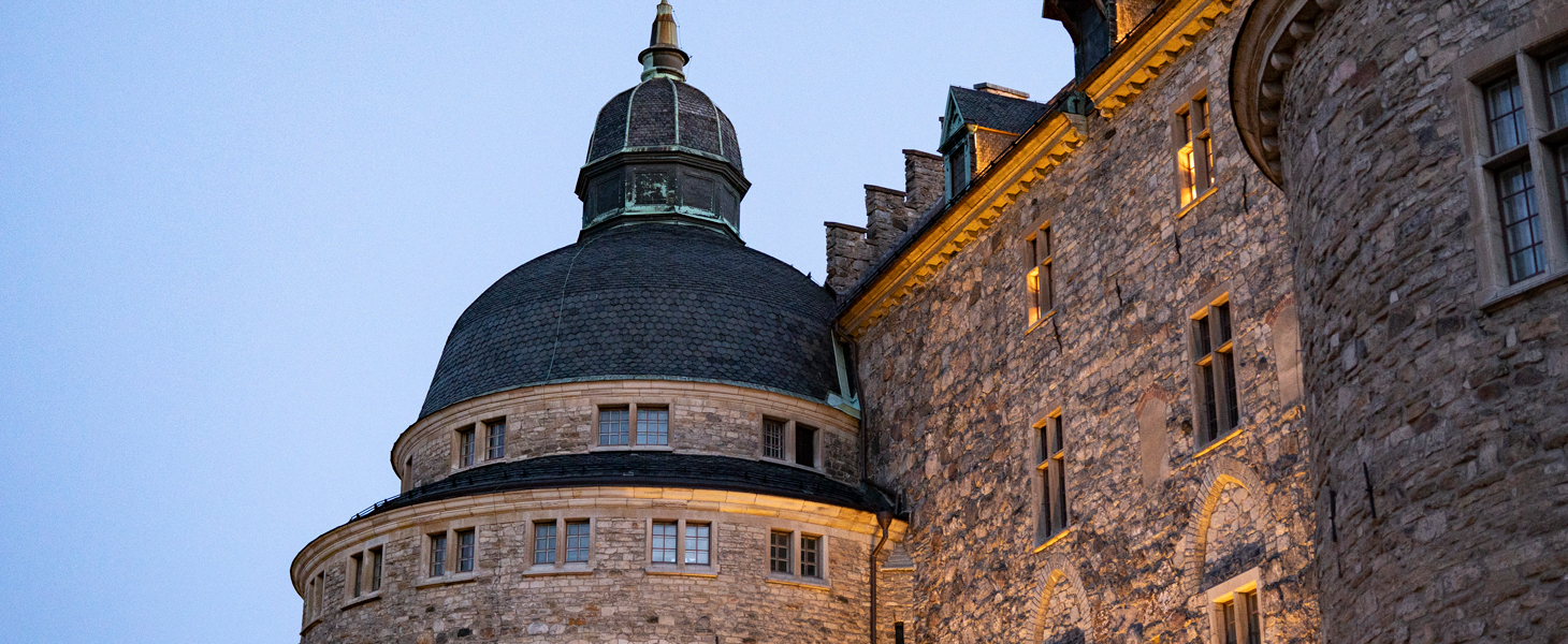 Bild på ett av tornen på Örebro slott i skymning.