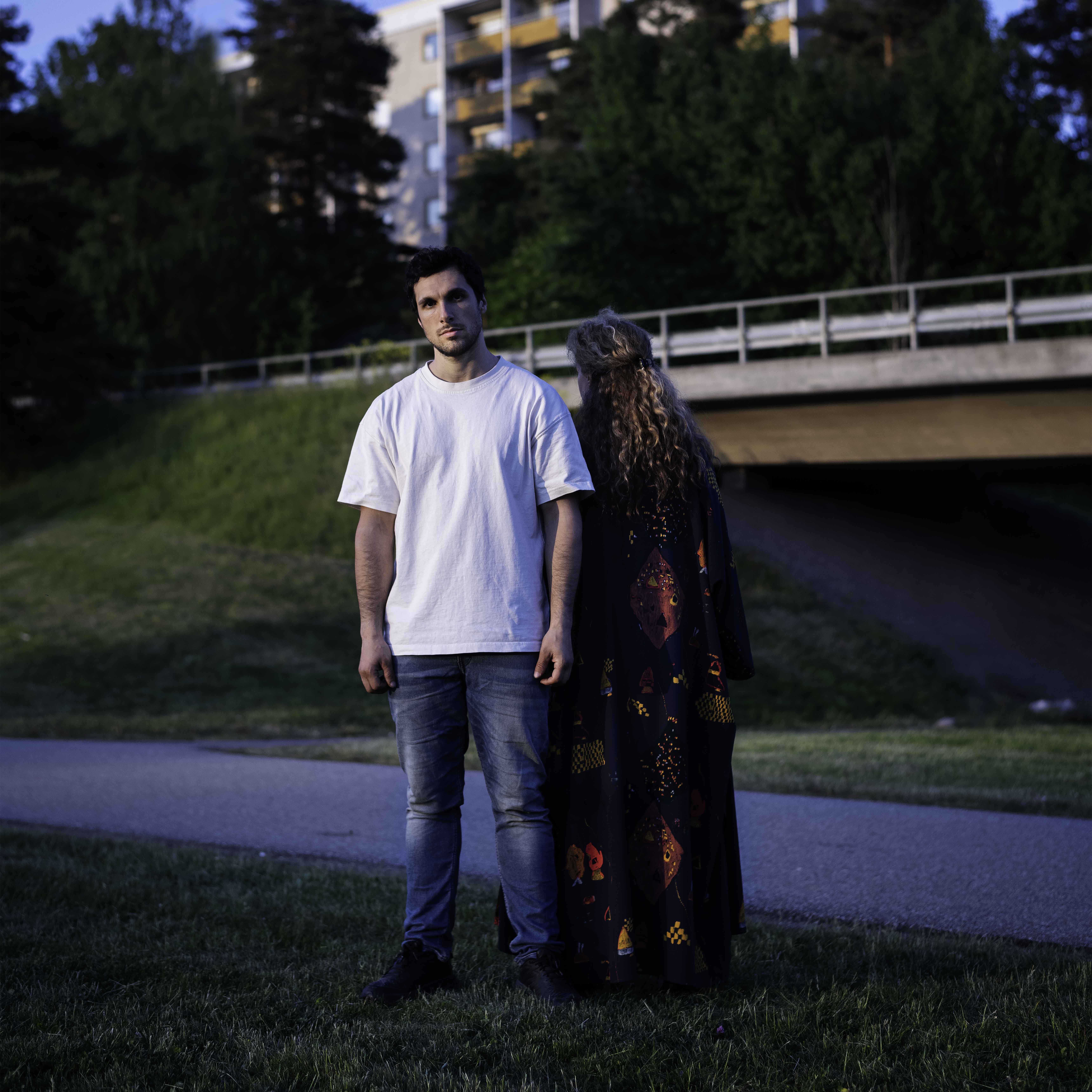 En ung man står på en slänt tillsammans med en kvinna 