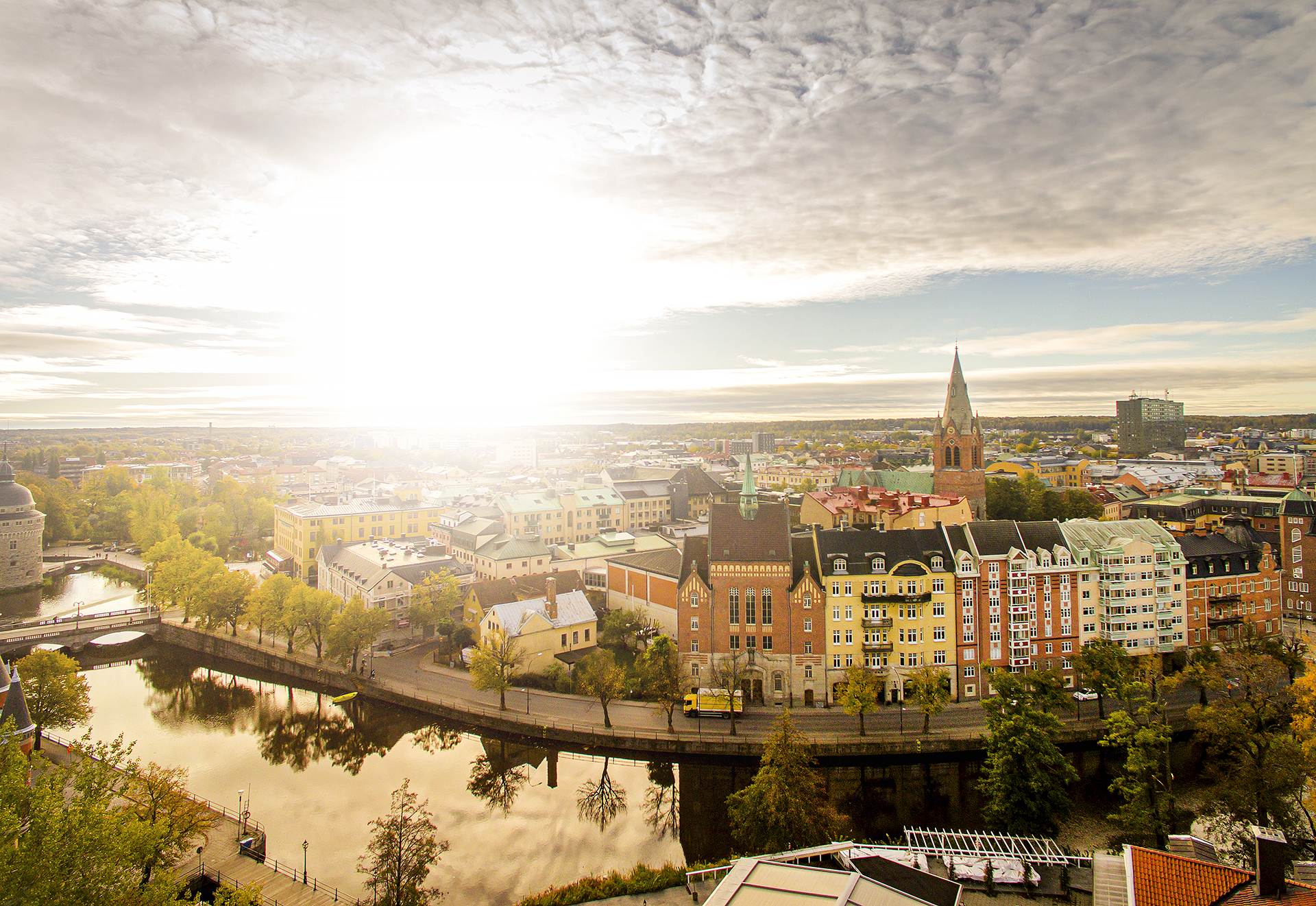 Bild från luften över Örebro och Svartån, med sol och höstens färger på träden